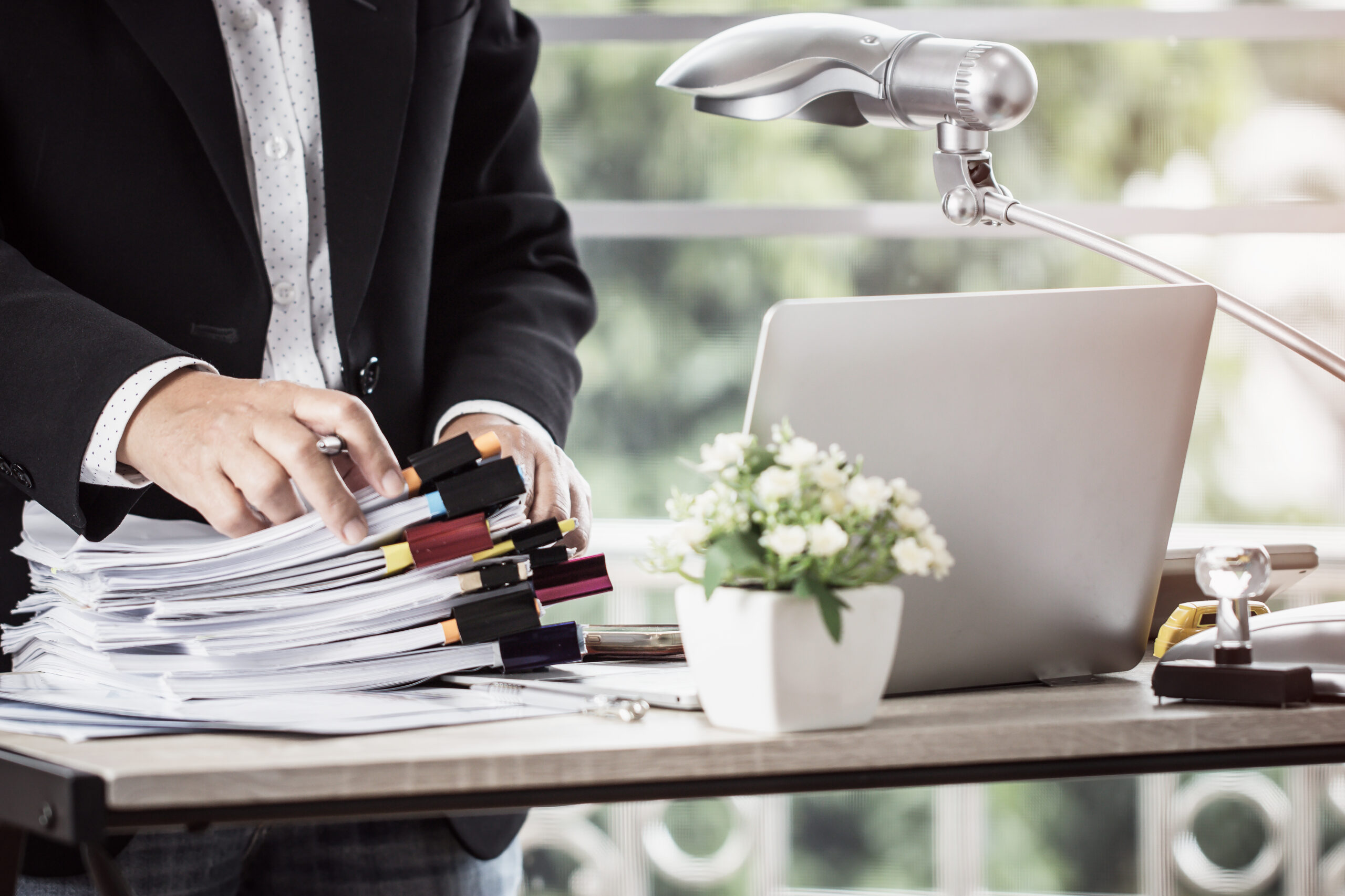 Man in suit holding documents during a virtual conference, preparing presentation as part of Fluid Resourcing professional workflow