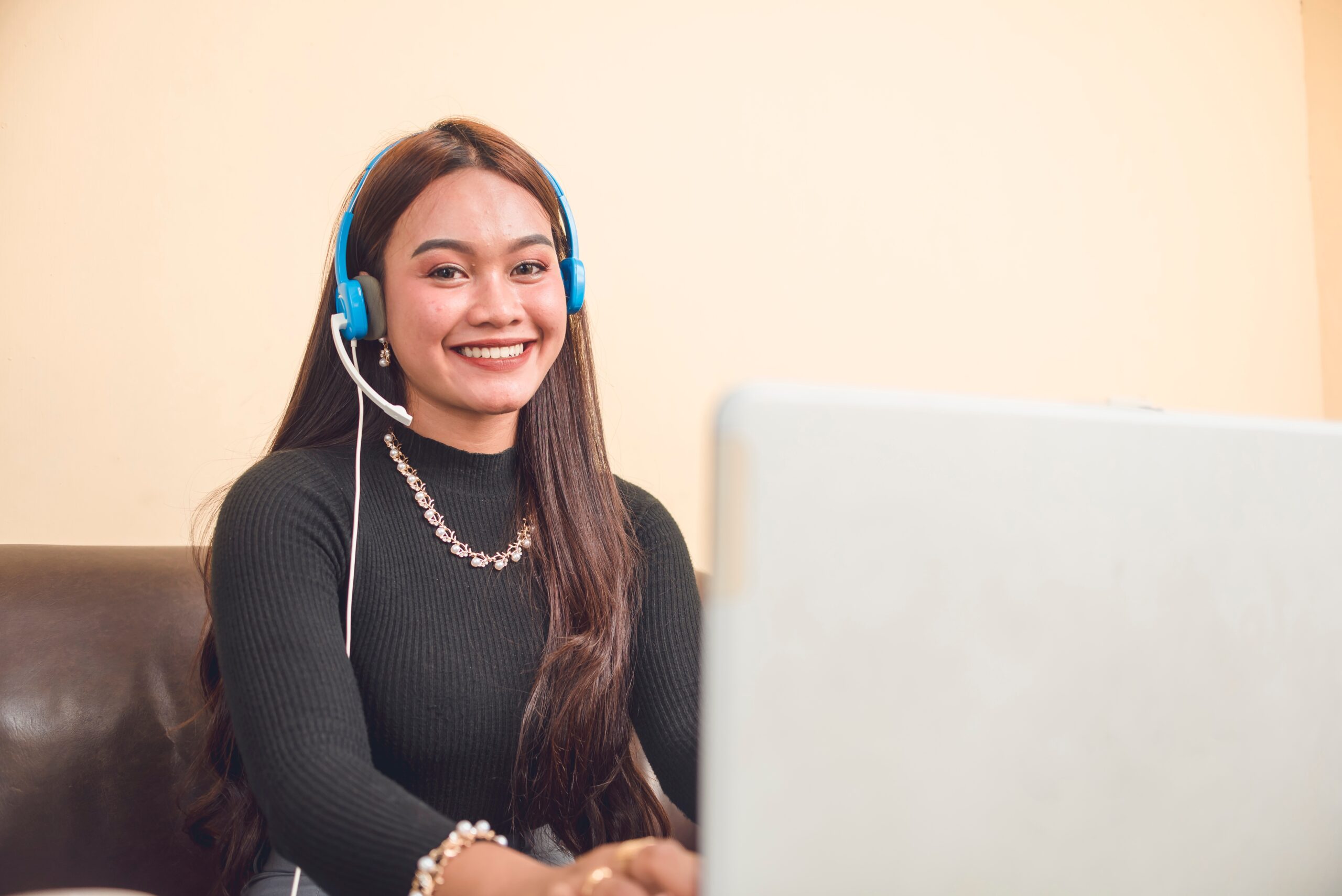 Young Asian virtual assistant working remotely on laptop, associated with Fluid Resourcing workforce and remote staffing solutions