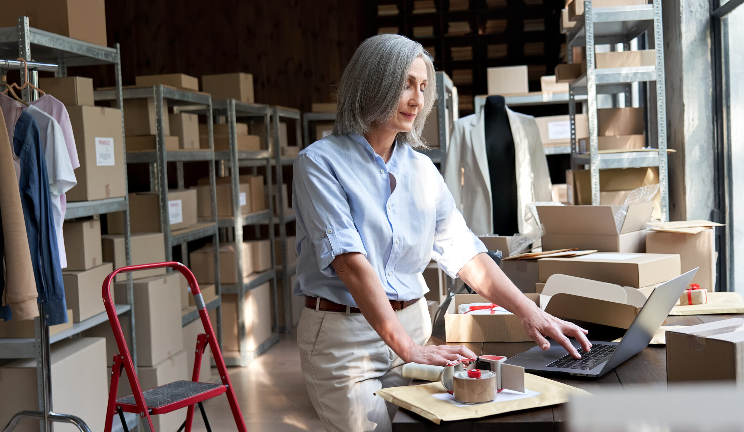 Middle-aged woman entrepreneur managing inventory, seeking support from Fluid Resourcing for efficient workflow and business productivity