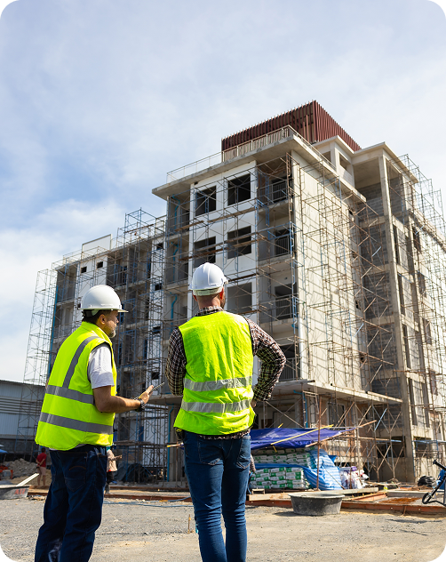 Two construction workers stand in front of a building, representing Fluid Resourcing with virtual talent from the Philippines