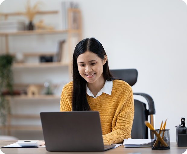 A woman smiling while using a laptop, representing virtual talent from the Philippines of Fluid Resourcing