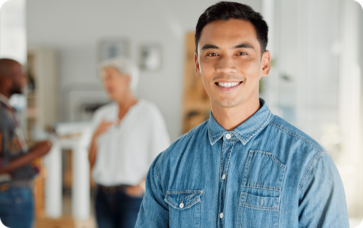 Man in denim shirt smiling at camera, reflecting Fluid Resourcing and a people-first approach to smarter team performance