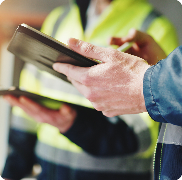 Two men in yellow vests are holding a tablet, representing Fluid Resourcing for Virtual Talent solutions